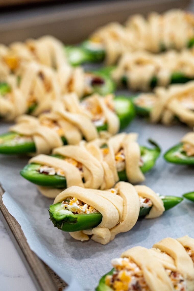 Wrapping the jalapeno poppers.